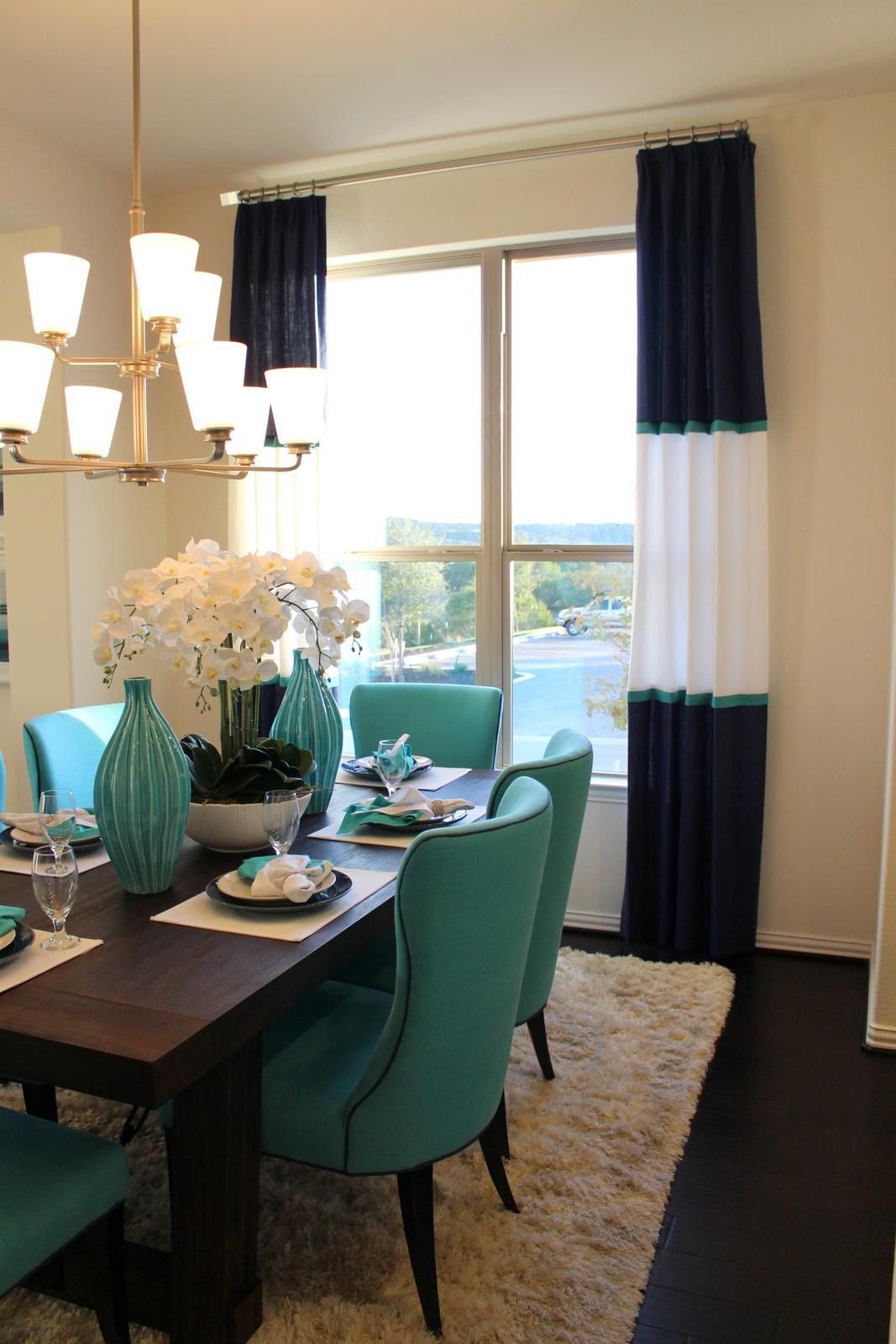 A dining room with a table and chairs and a window
