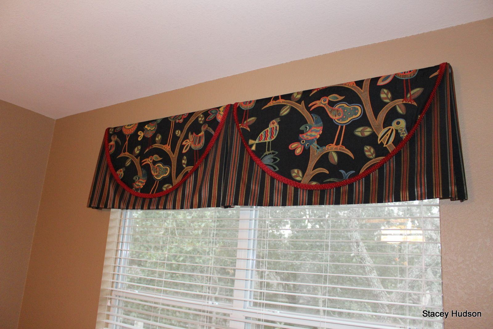 A window with blinds and a valance on it.