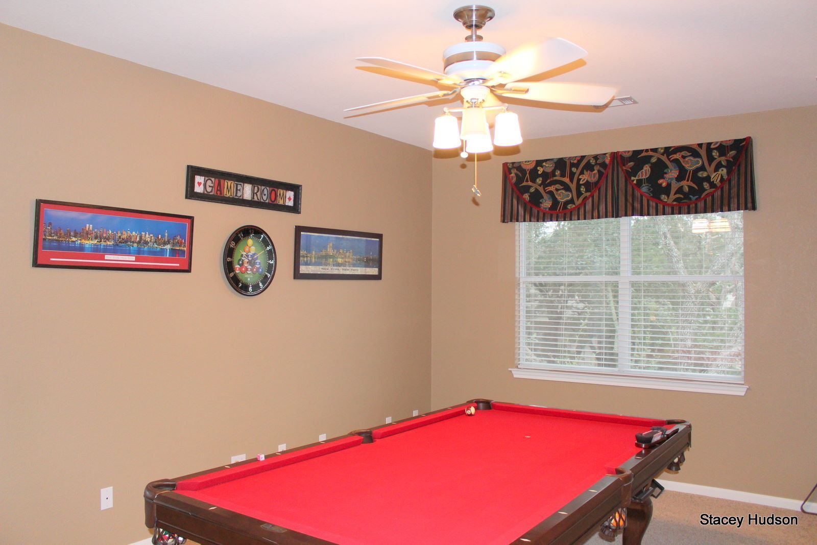 A pool table in a room with a ceiling fan