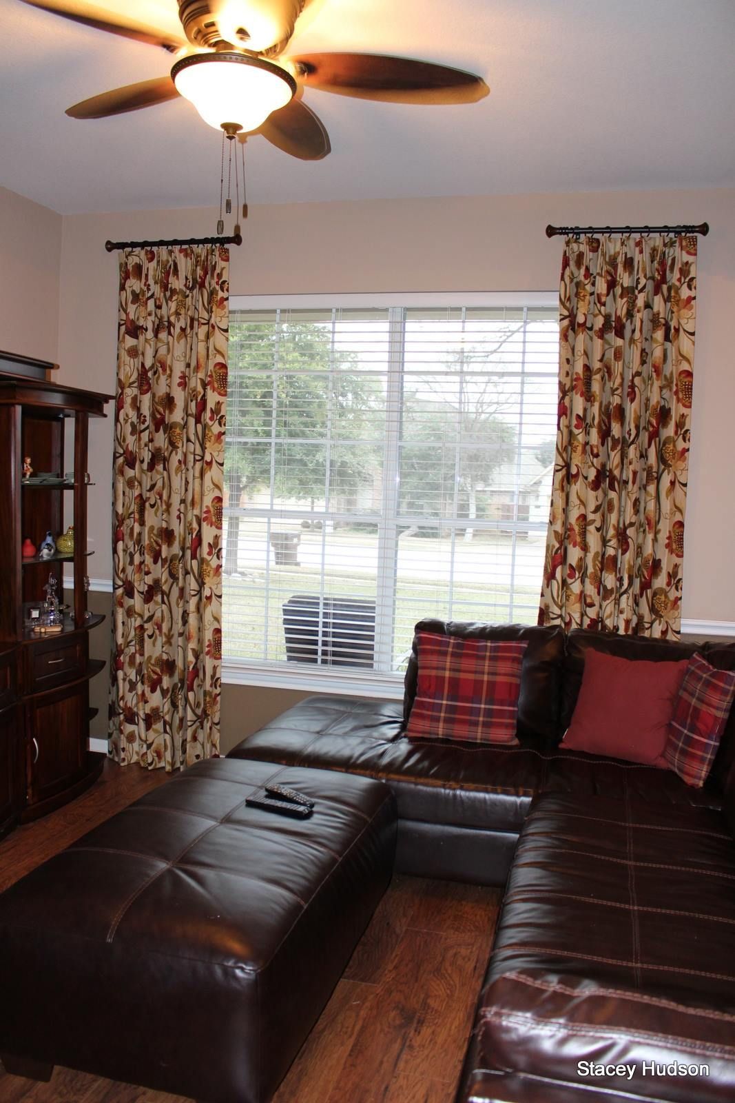 A living room with a sectional couch and a ceiling fan