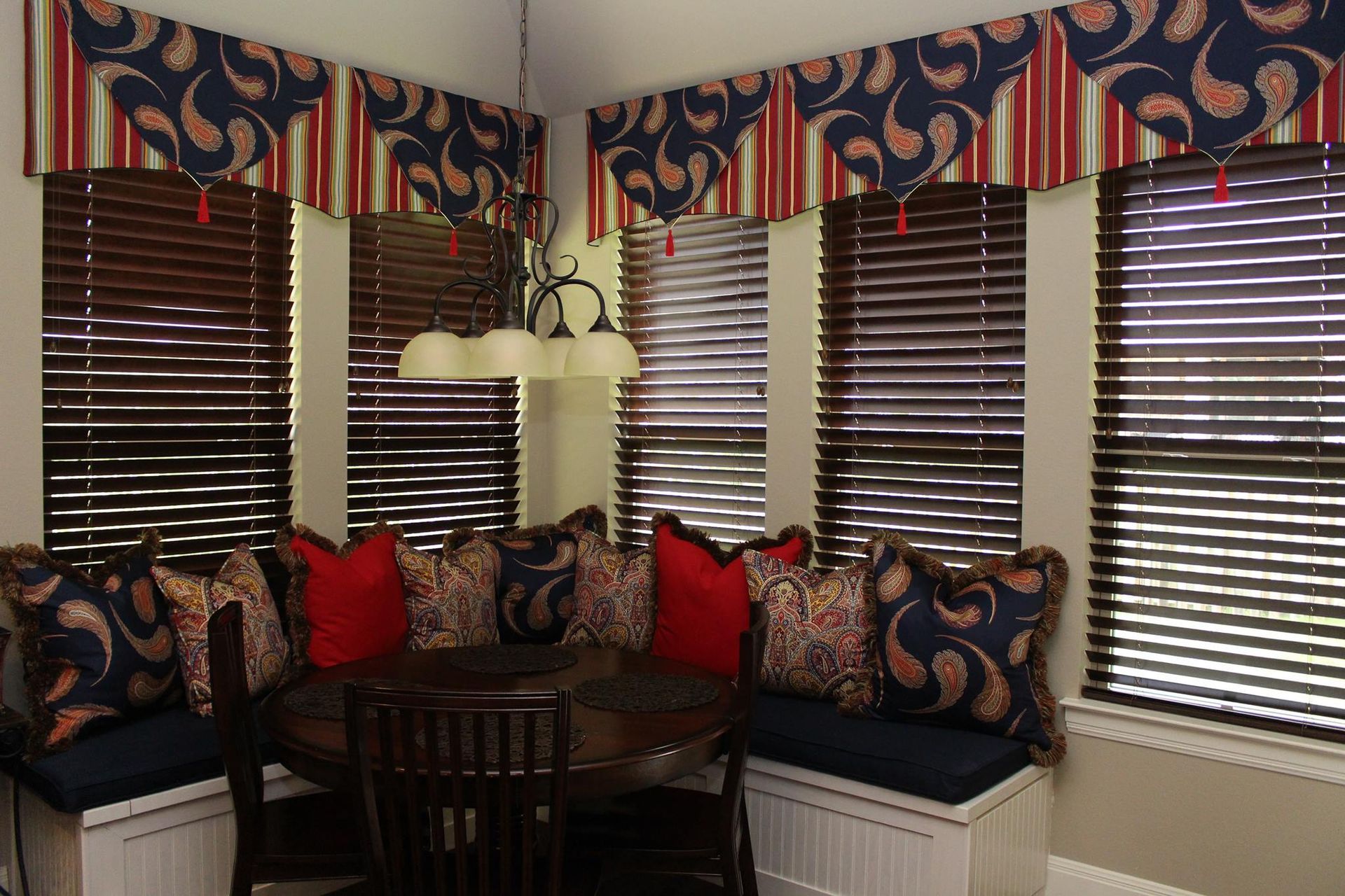 A dining room with a table and chairs and a window seat.
