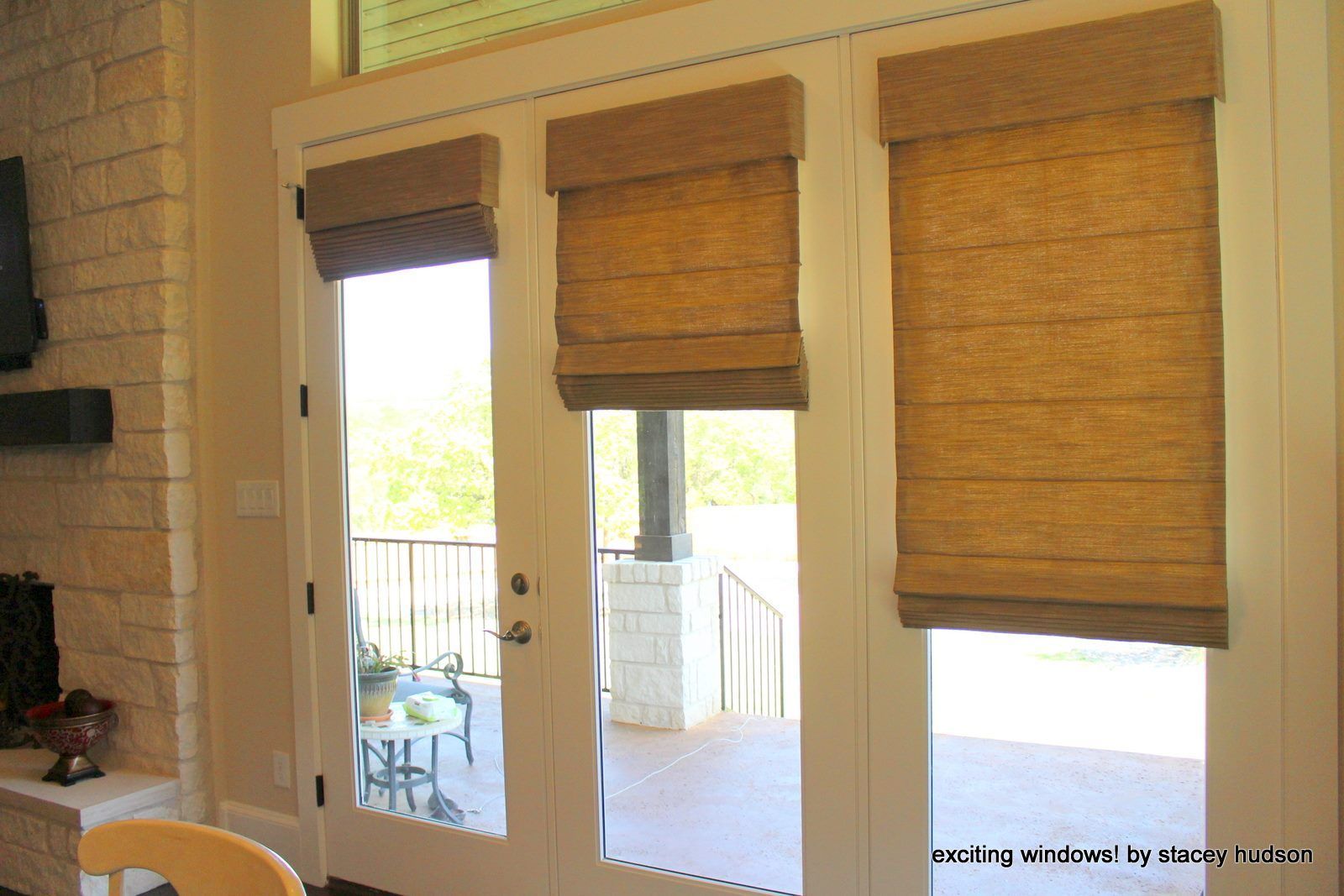 A sliding glass door with roman shades on it
