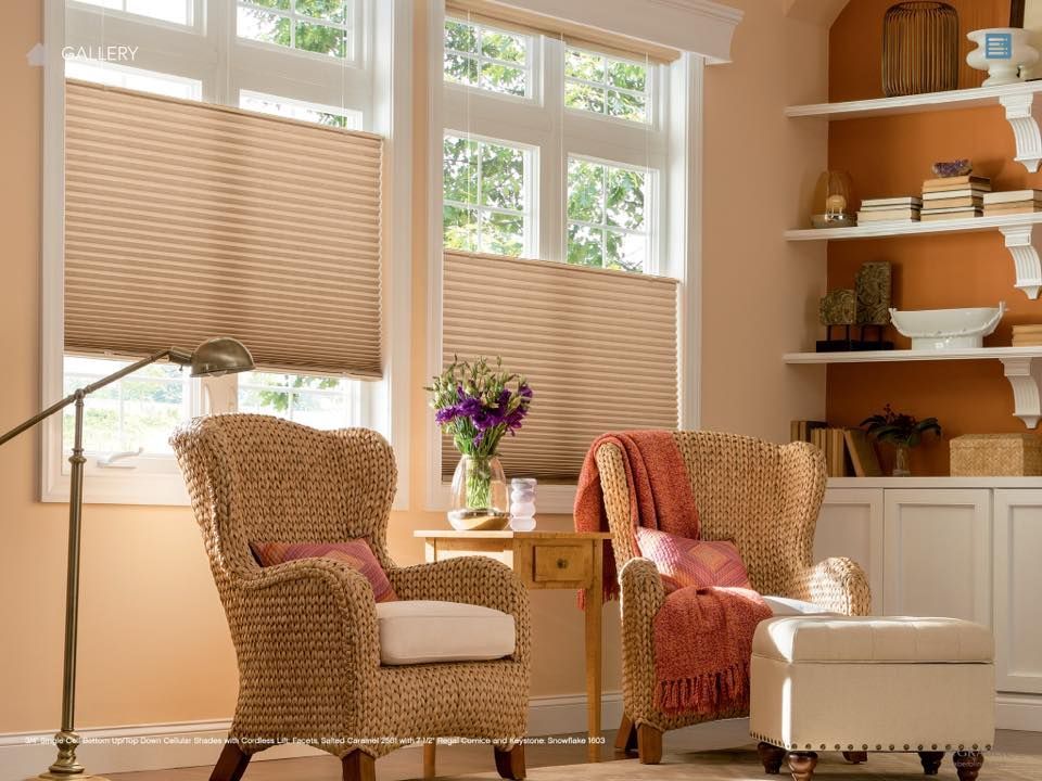 A living room with two chairs , a table , and shelves.