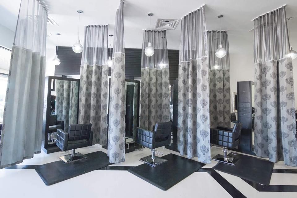 A hair salon with a lot of chairs and curtains.