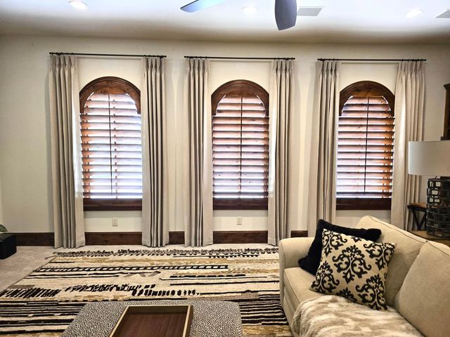 A living room with a couch , coffee table , and arched windows.