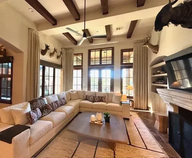 A living room with a large sectional couch and a fireplace