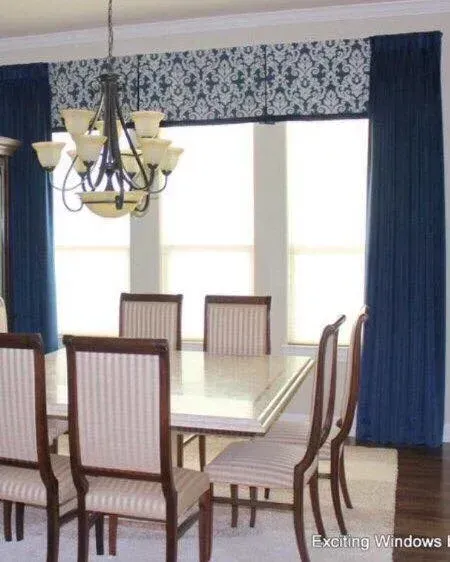 A dining room with a table and chairs and a chandelier
