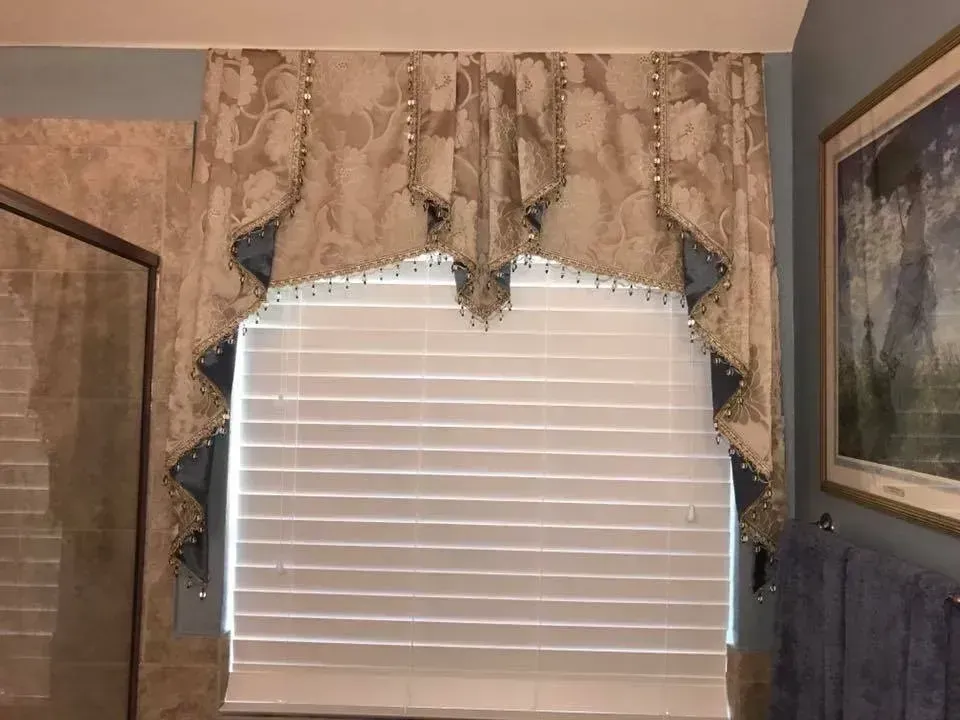 A bathroom with a large window and a picture on the wall.