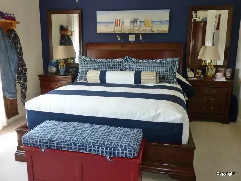 A bedroom with a king size bed and a bench