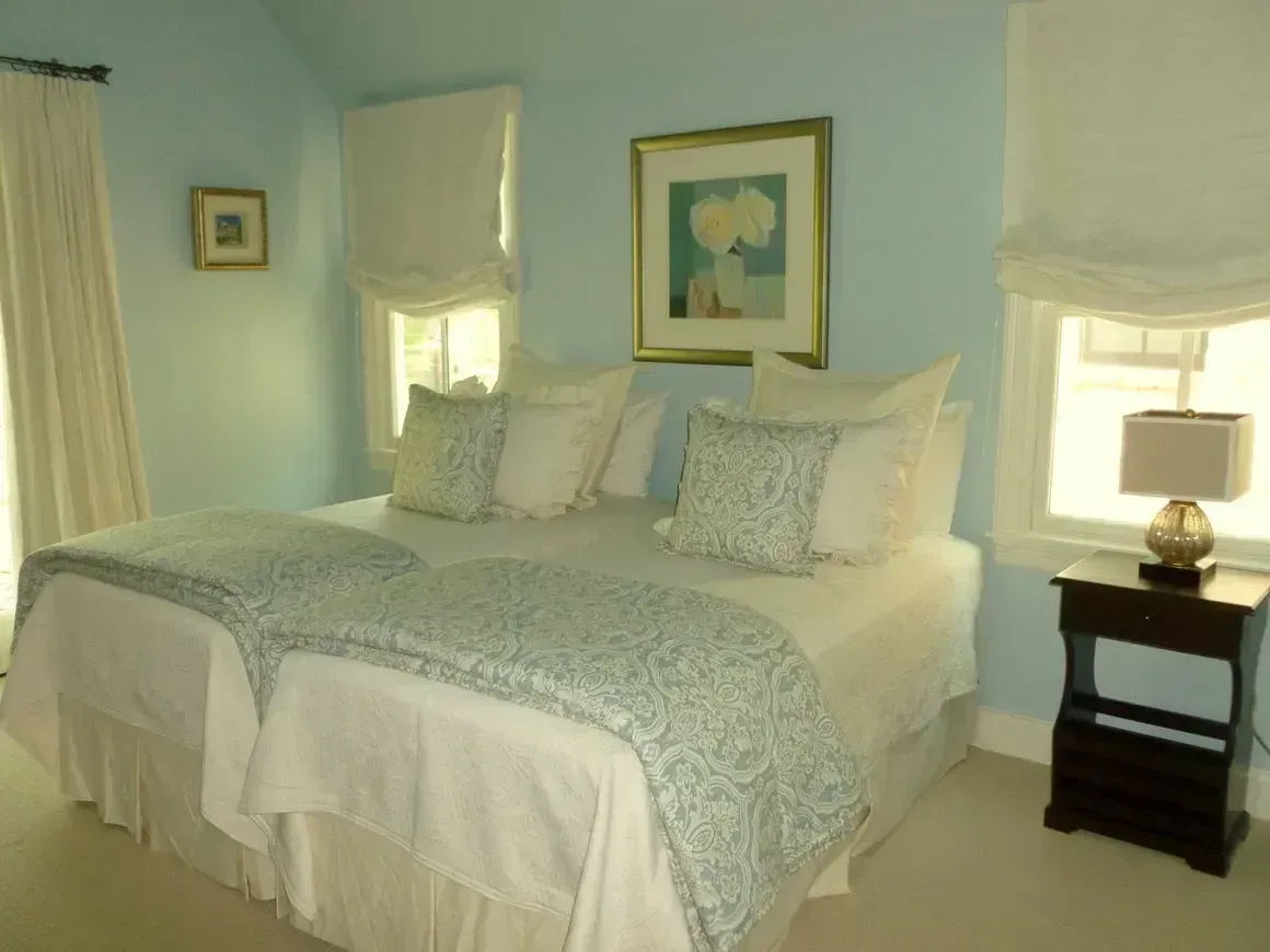 A bedroom with two beds and a nightstand