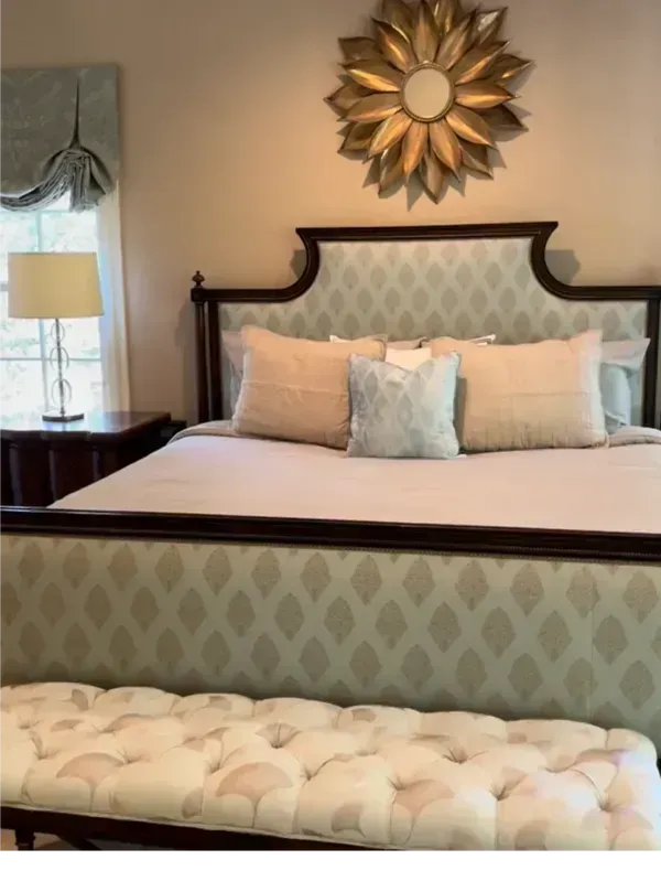 A bedroom with a bed and a mirror on the wall