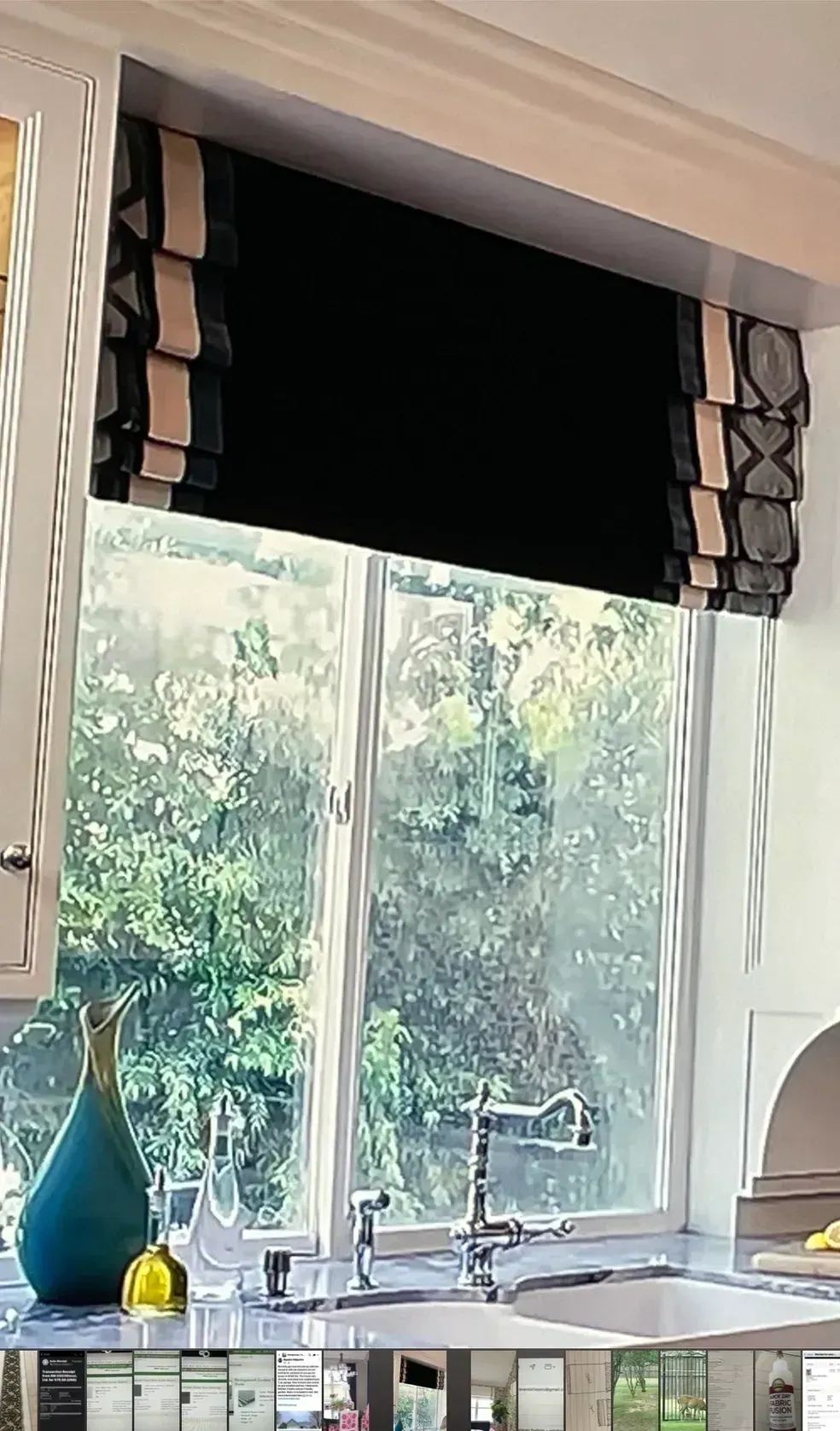 A kitchen with a sink and a window with a black blind on it.