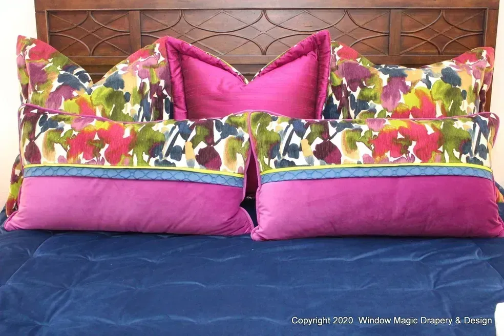 A bed with a wooden headboard and colorful pillows on it