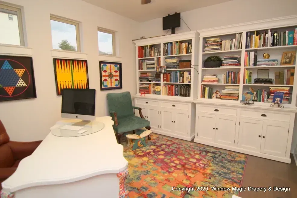 A home office with a desk , chair , bookshelf and computer.