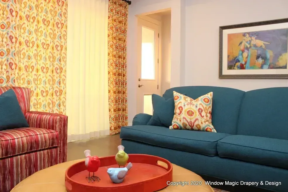 A living room with a blue couch and a red chair.