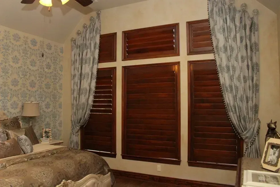 A bedroom with a bed and a ceiling fan
