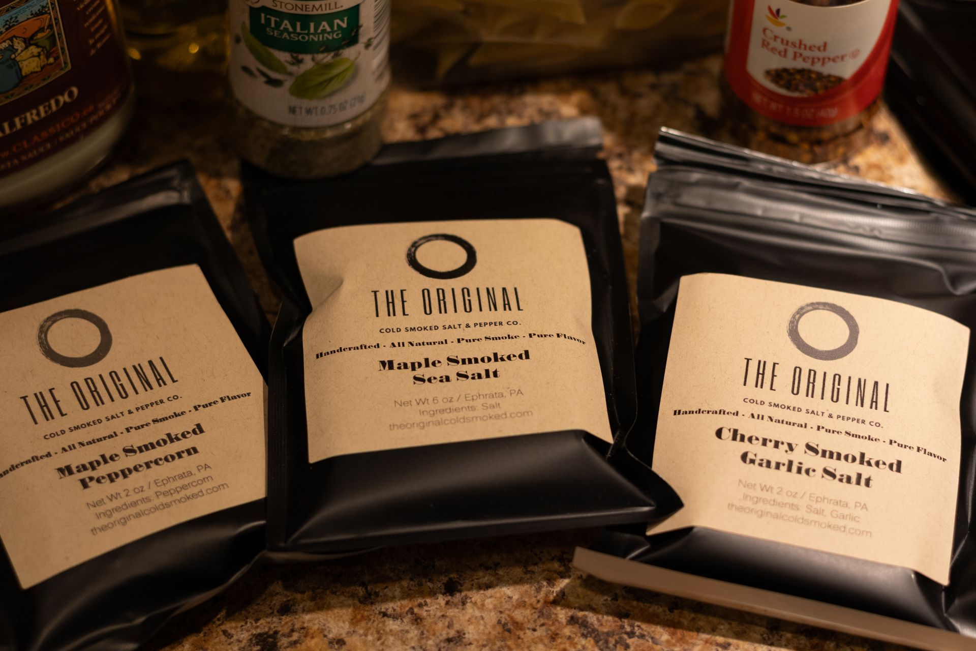 Three bags of the original spices are sitting on a counter