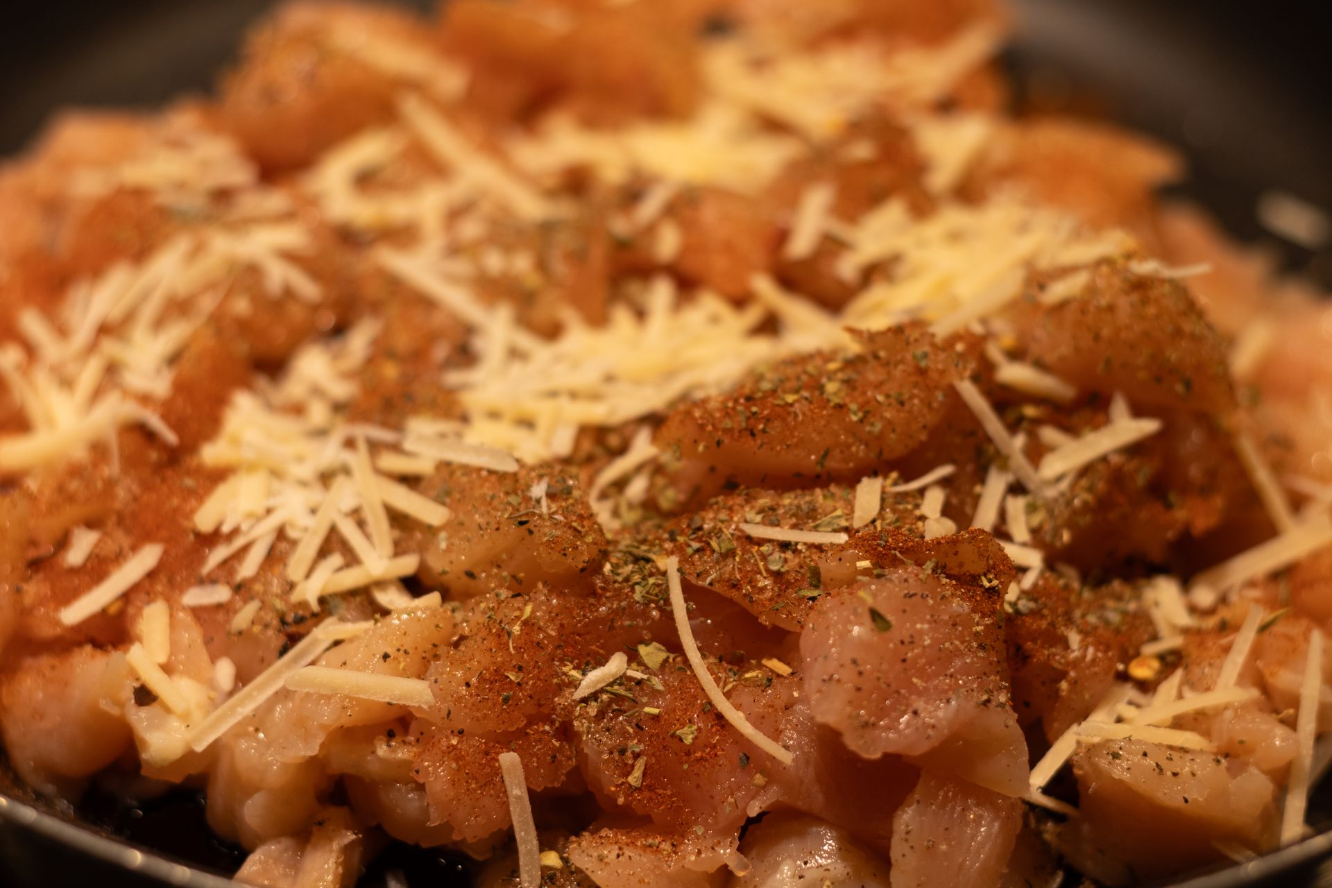 A close up of a pan filled with chicken and cheese.