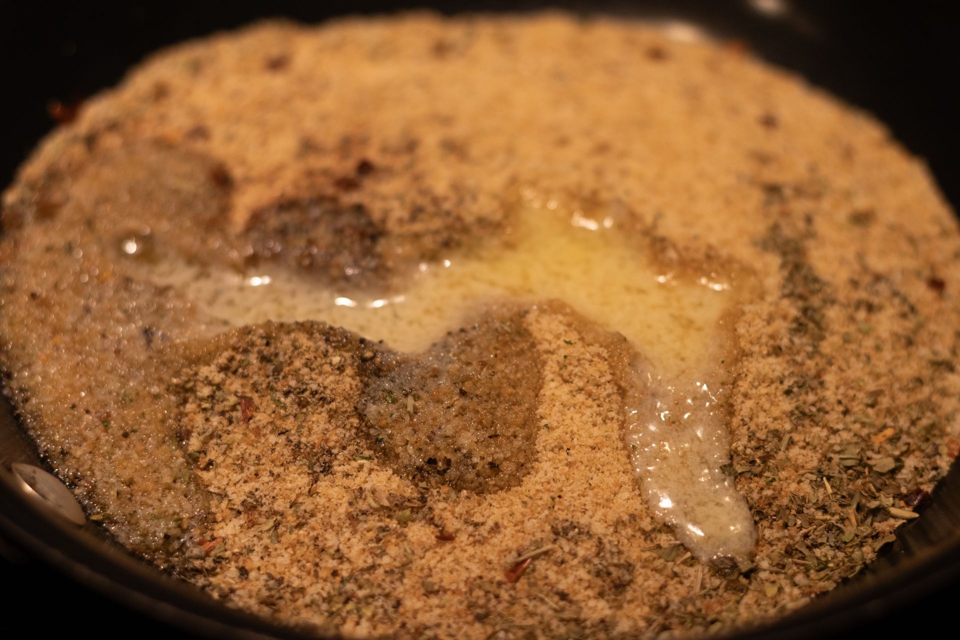 A close up of a pan filled with bread crumbs and butter