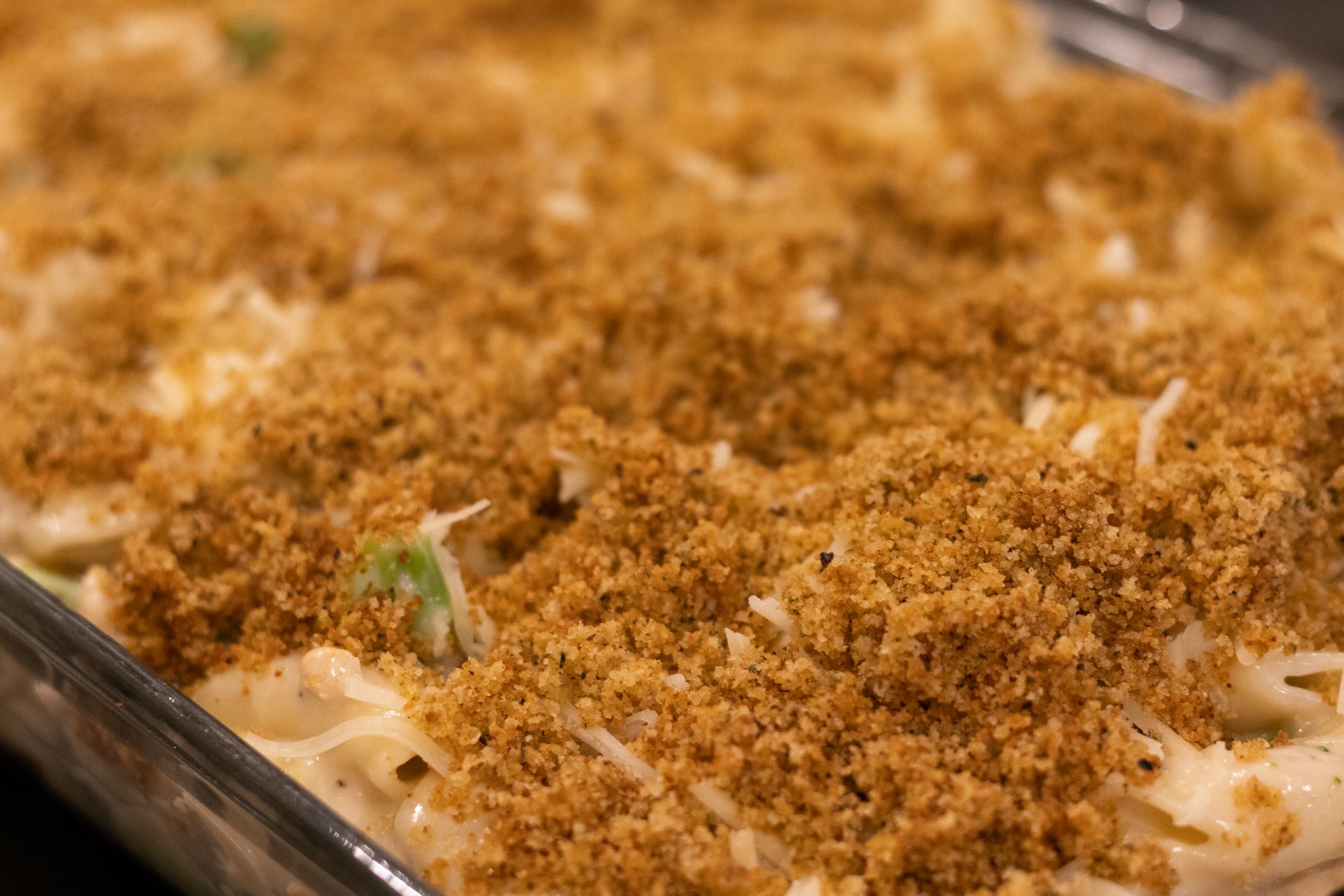 A close up of a casserole dish filled with macaroni and cheese and bread crumbs.