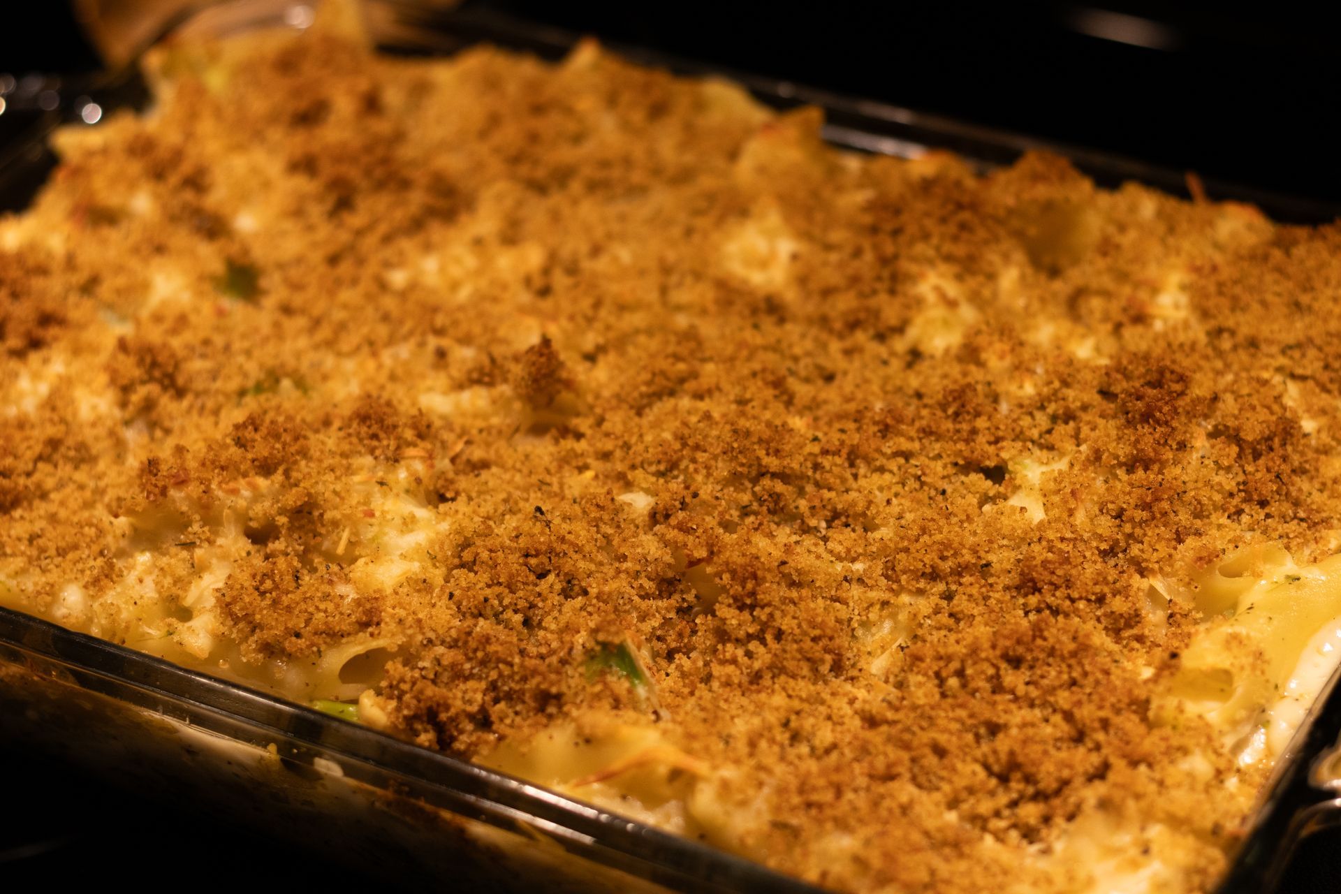 A casserole dish filled with macaroni and cheese and bread crumbs.