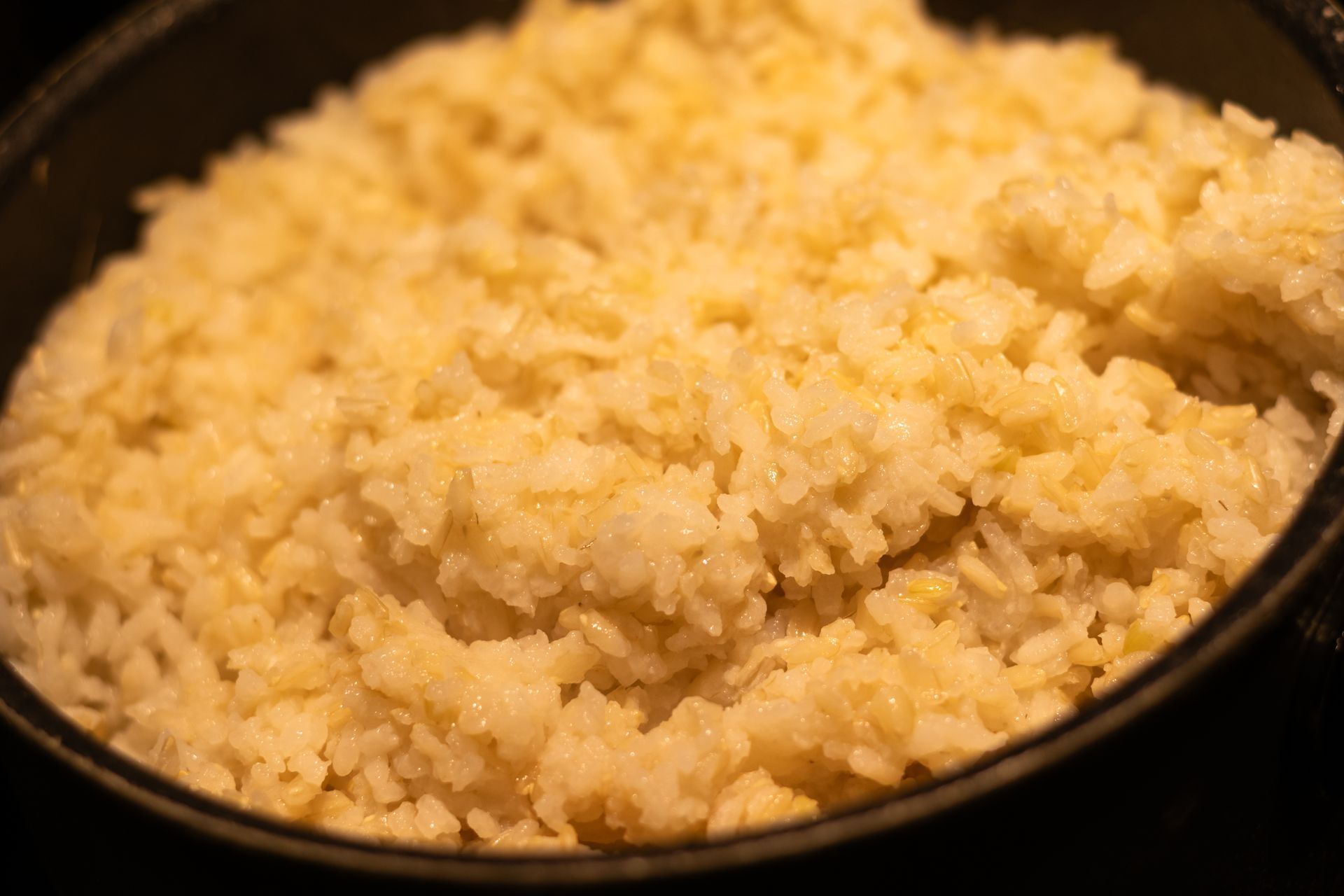 A close up of rice in a pan on a stove.