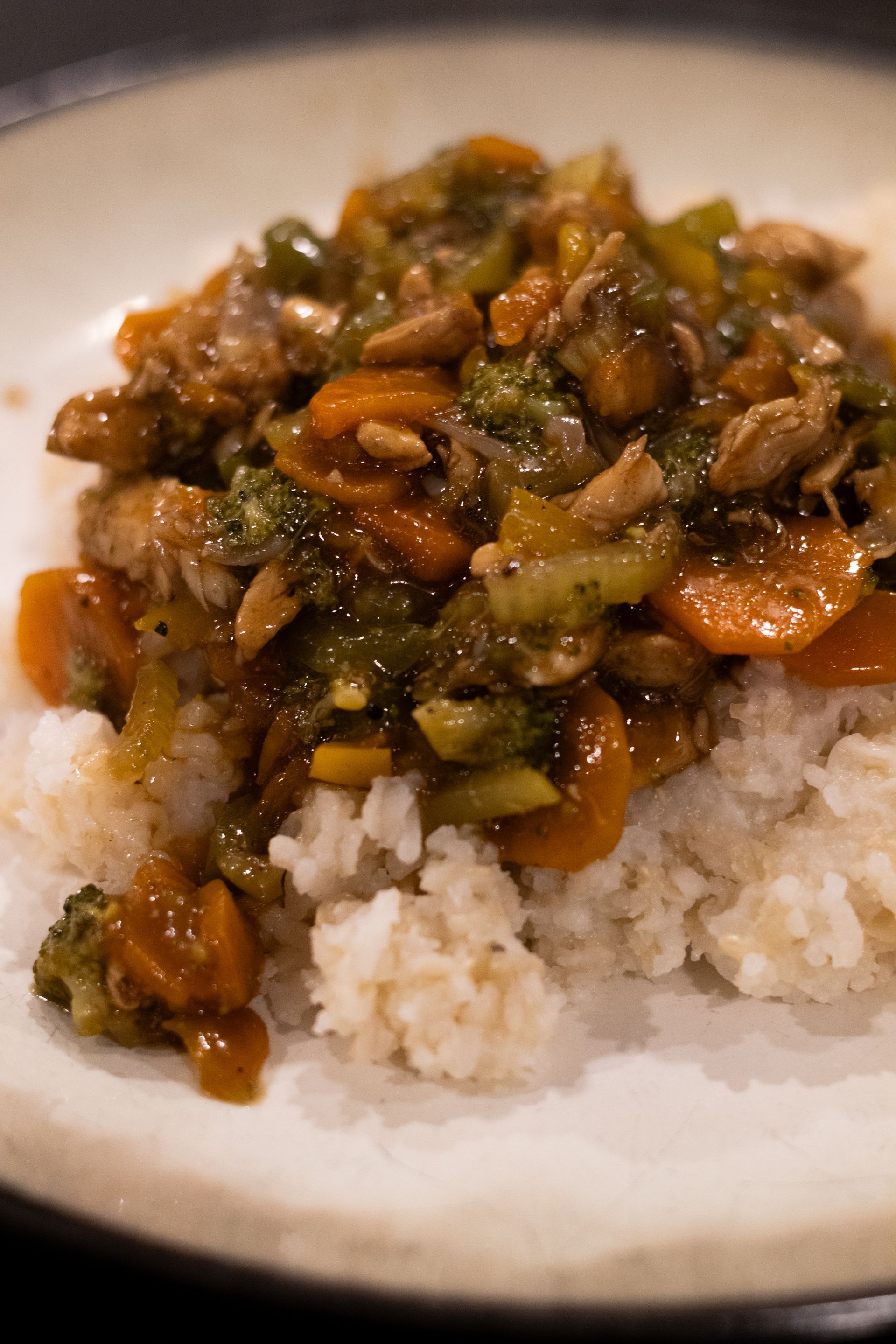 A close up of a plate of food with rice and vegetables on a table.