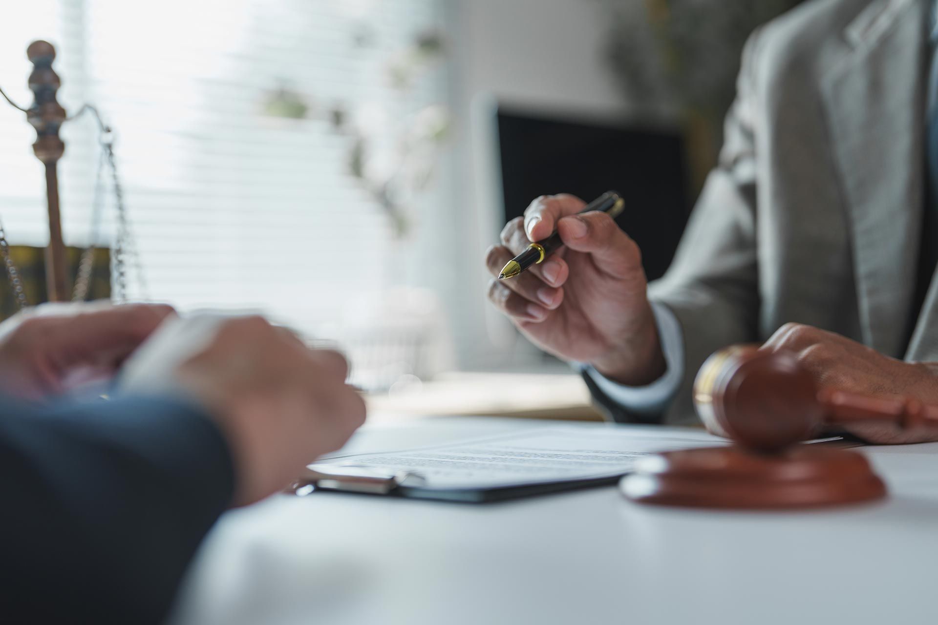 Attorney holding a pen while discussing estate documents with a client