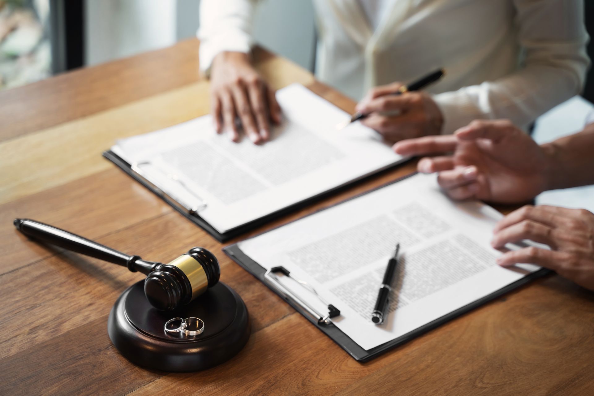 Divorce paperwork with gavel and wedding rings on desk. Divorce paperwork with gavel and wedding rings on desk.
