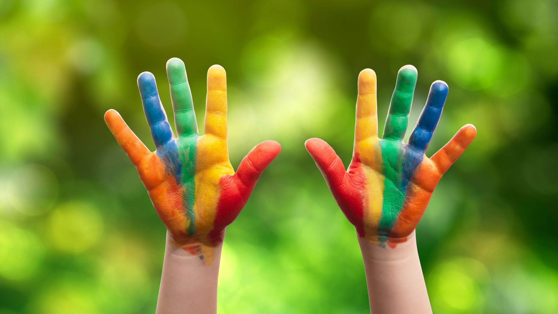 Child with painted hands in the park.