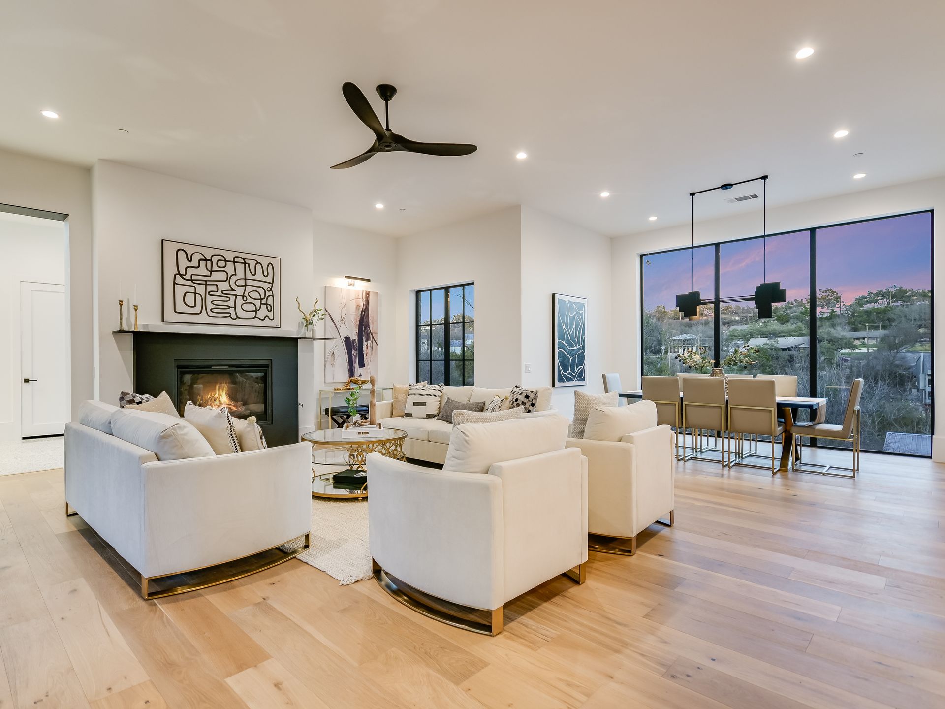 A living room filled with furniture and a fireplace with a ceiling fan.