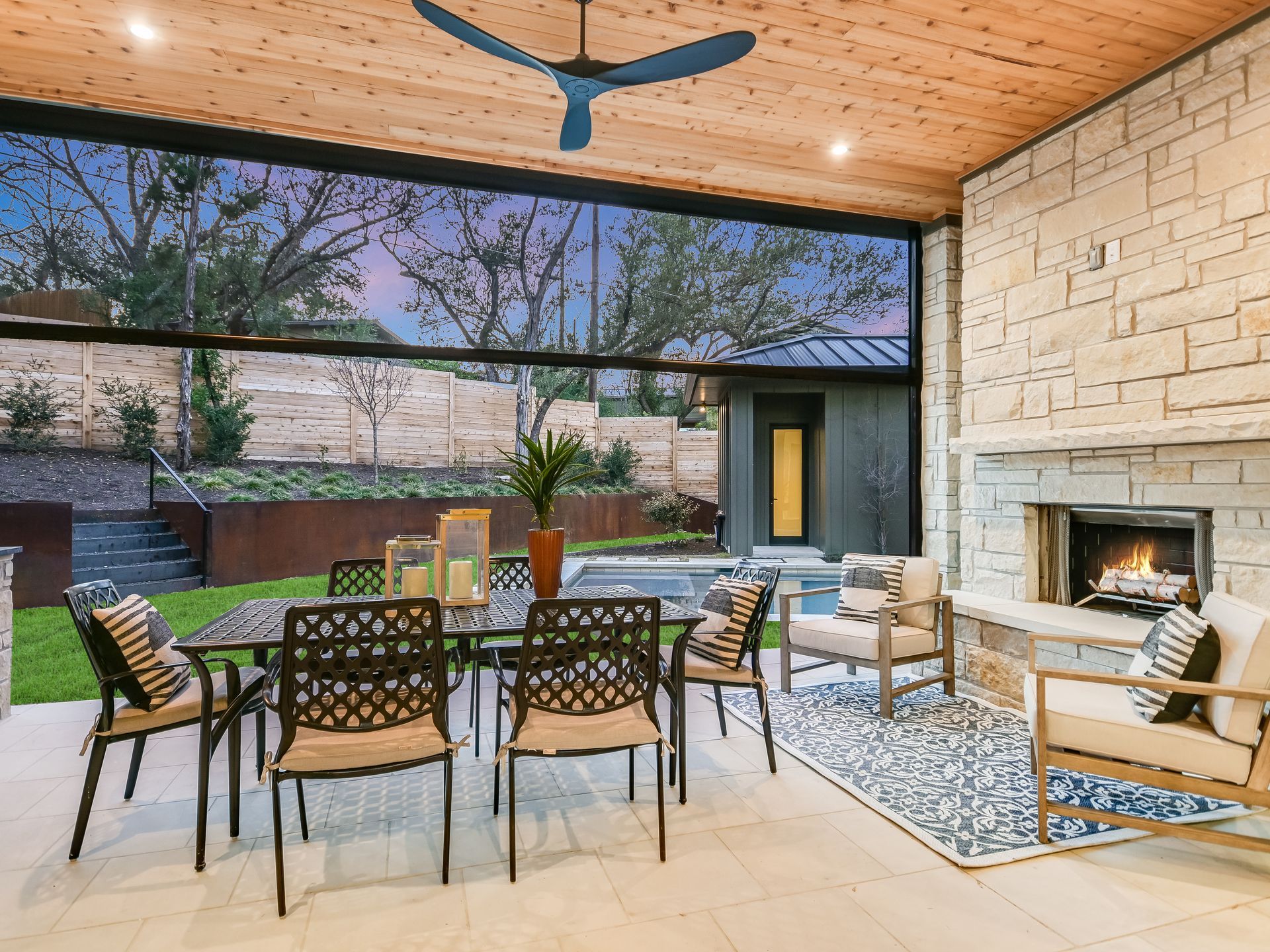 A patio with a table and chairs and a fireplace.
