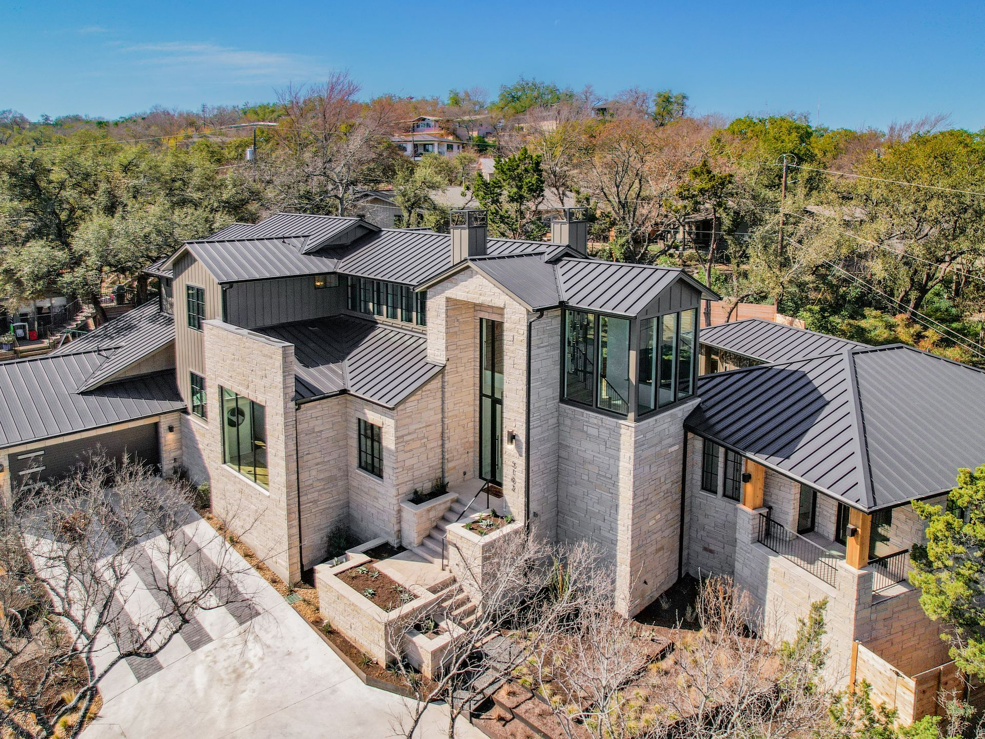 An aerial view of a large house surrounded by trees.