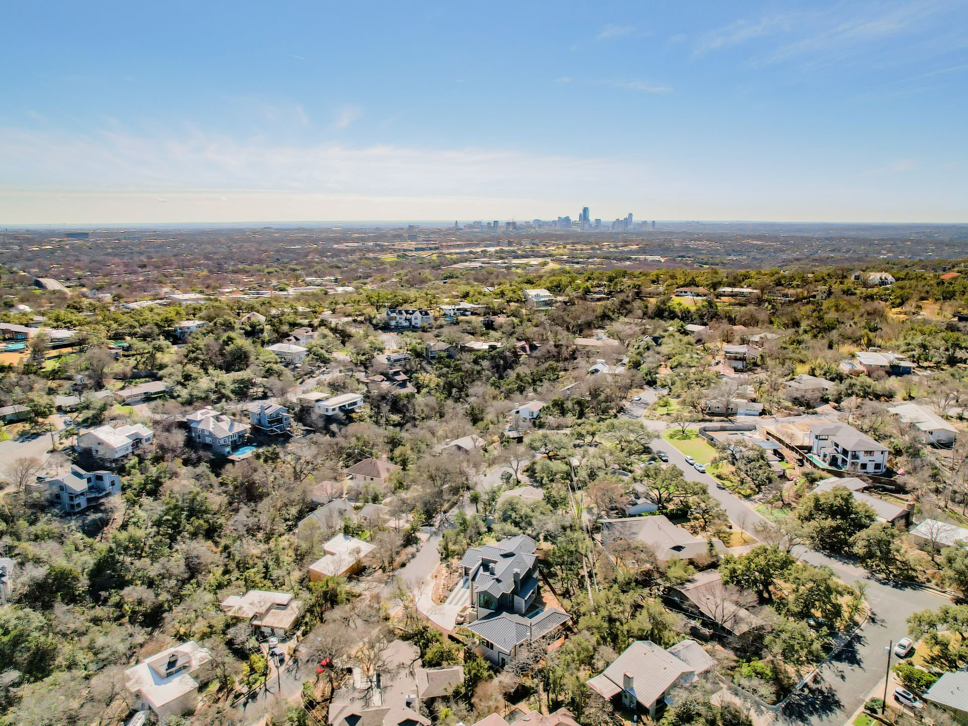 An aerial view of a residential area with a city in the background.