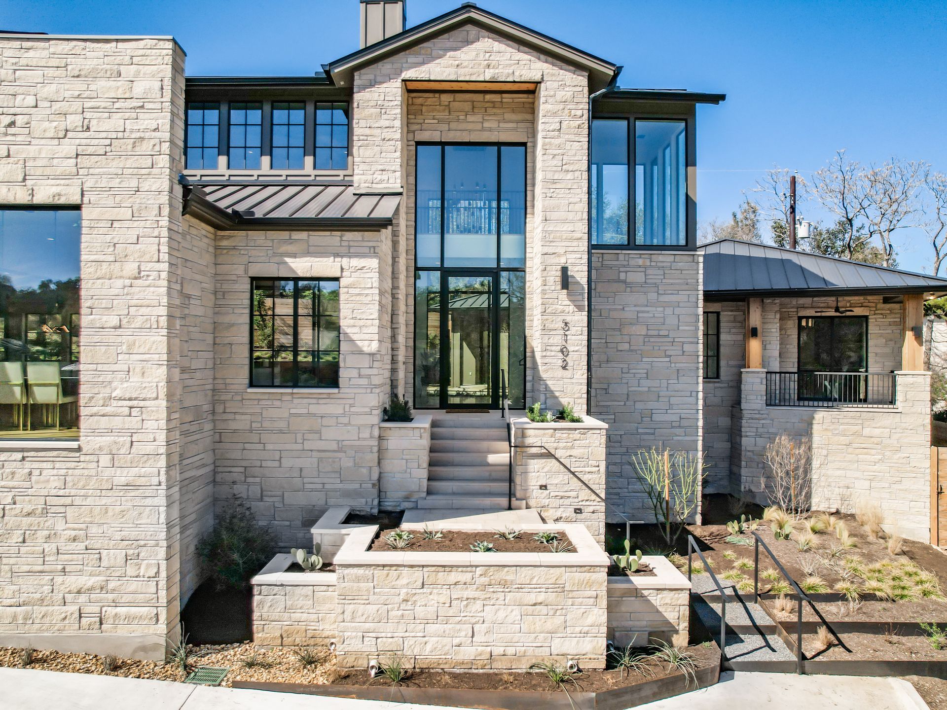 A large brick house with a lot of windows and stairs leading up to it.