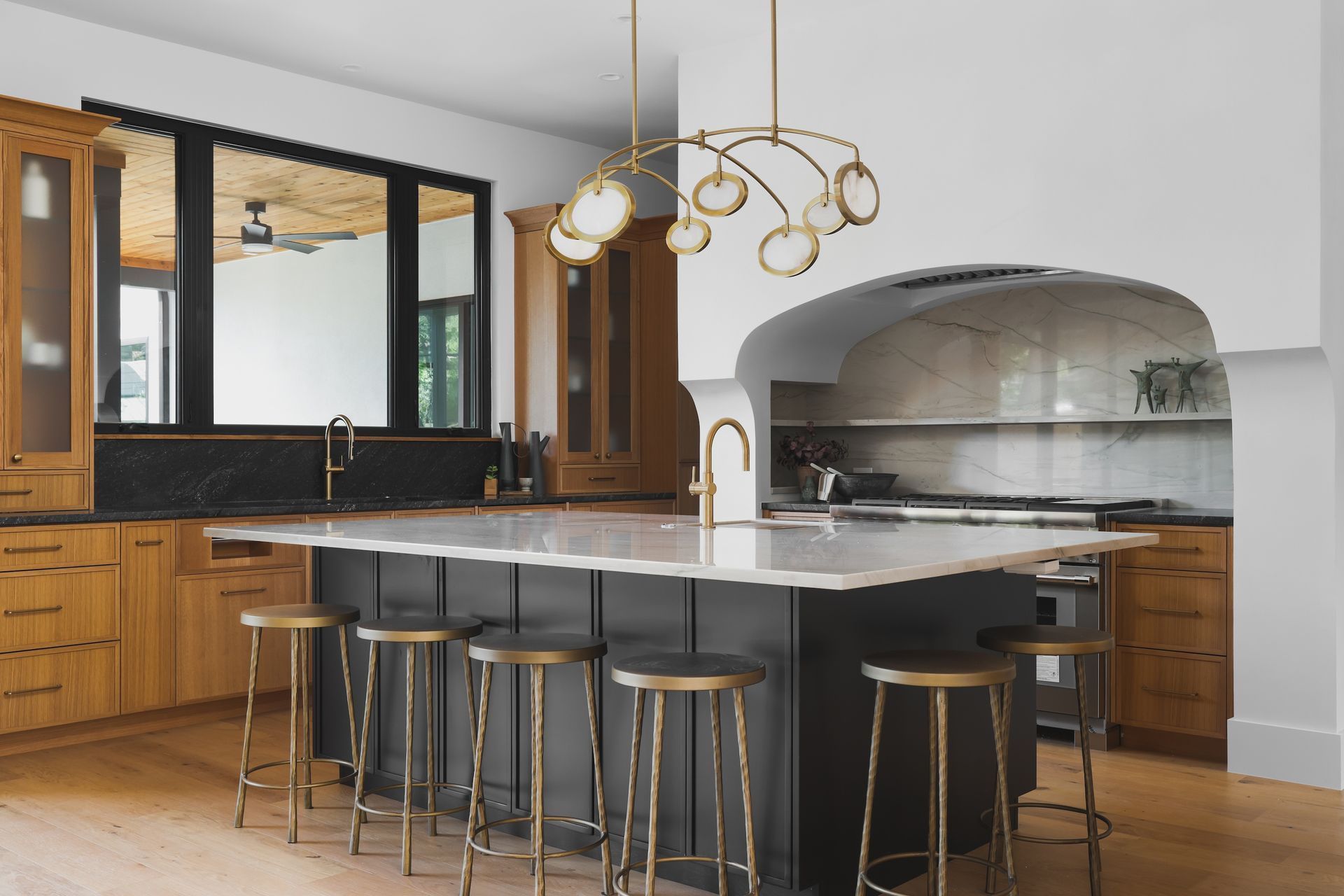 Modern kitchen with an island, cabinets, and a unique light fixture.
