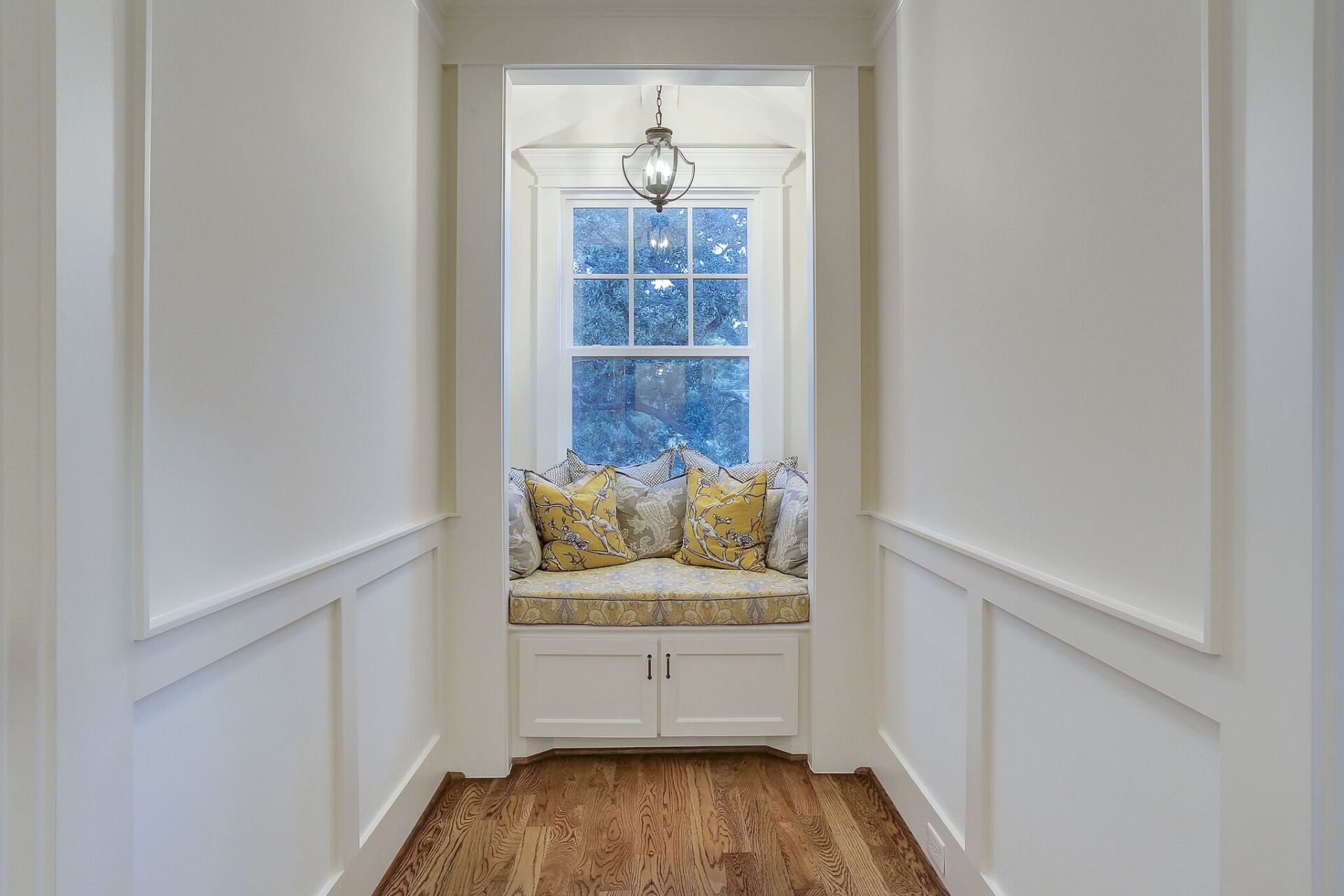 A hallway with a window seat in the middle of it.