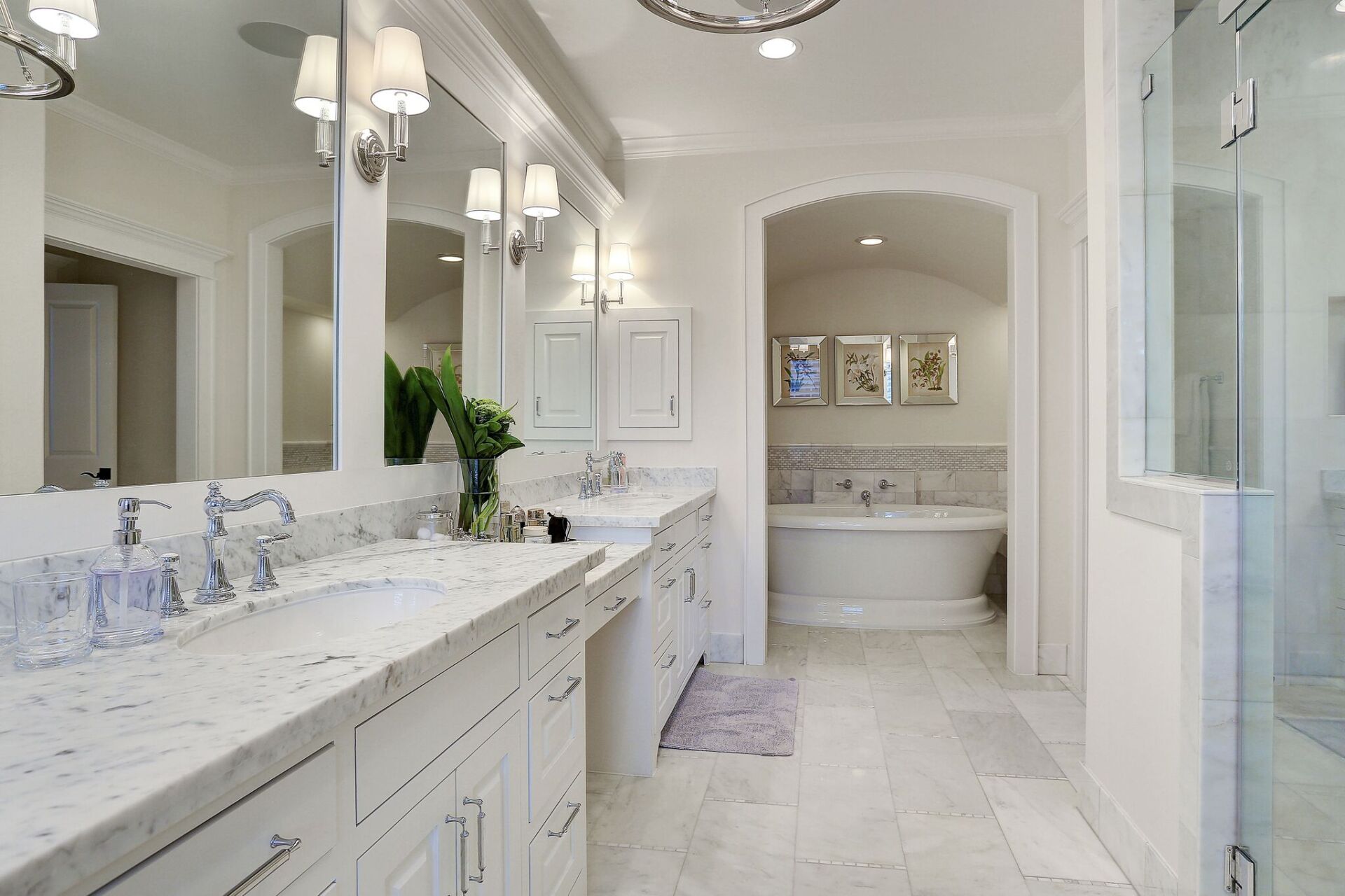 A bathroom with two sinks , two mirrors , a tub and a walk in shower.
