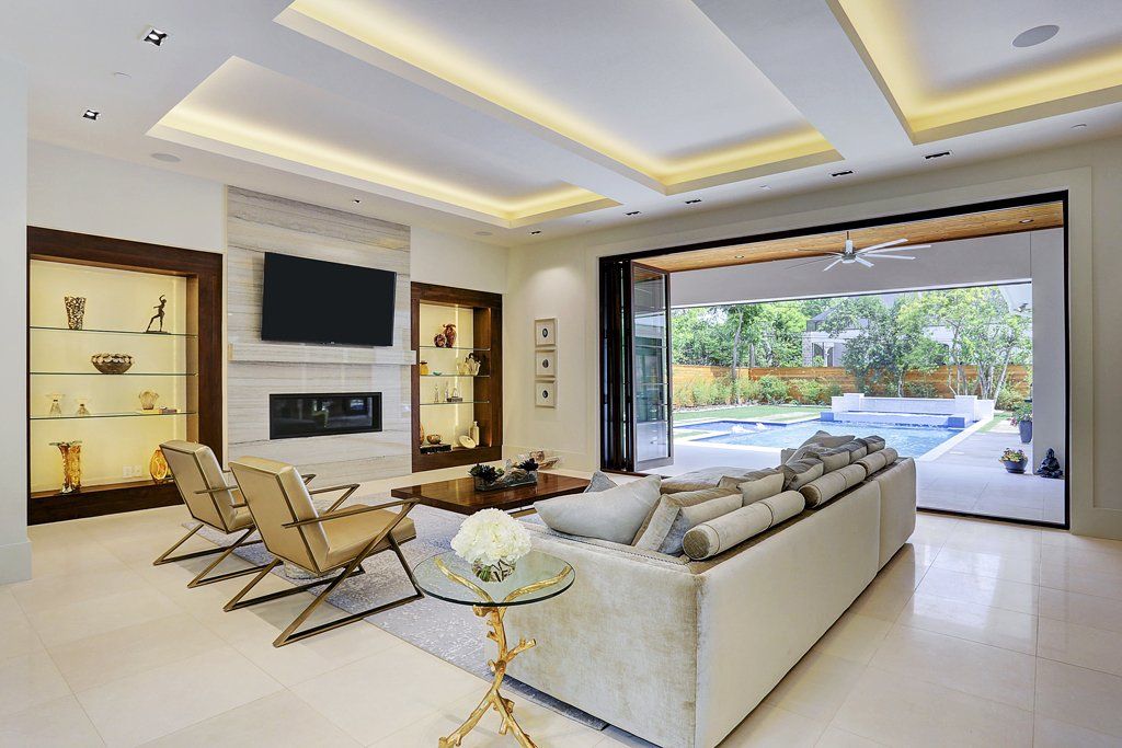 A living room with a couch , chairs , a television and a fireplace.