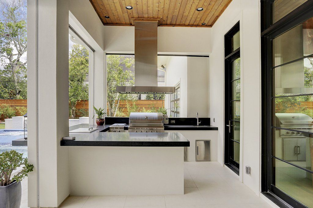 A kitchen with a large island and a stainless steel grill.
