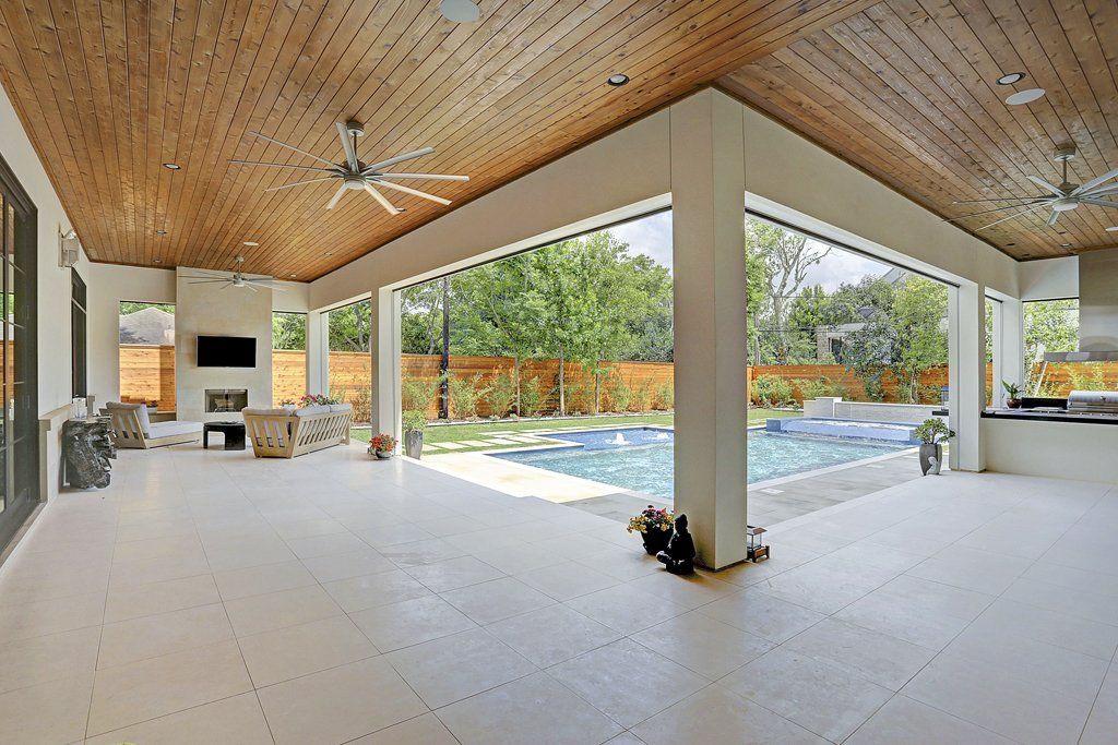 A large patio with a pool and a ceiling fan