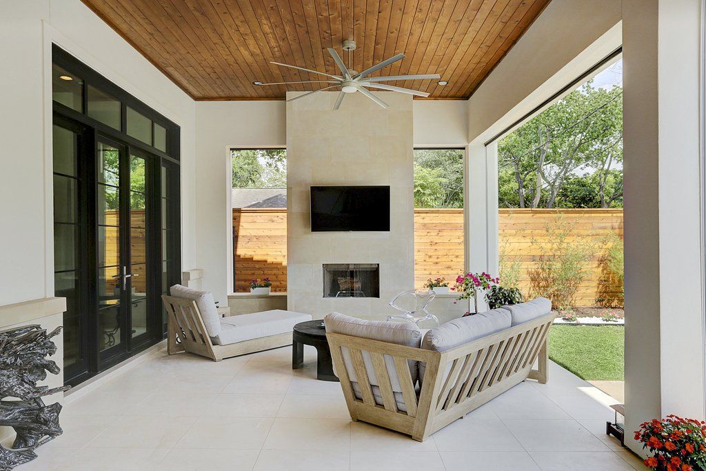 A living room with a couch , chairs , a fireplace and a flat screen tv.