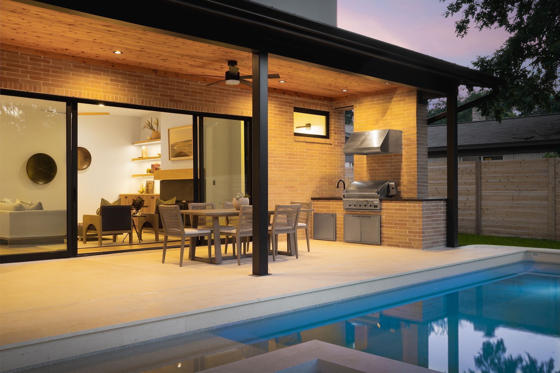 There is a large swimming pool in the backyard of a house.