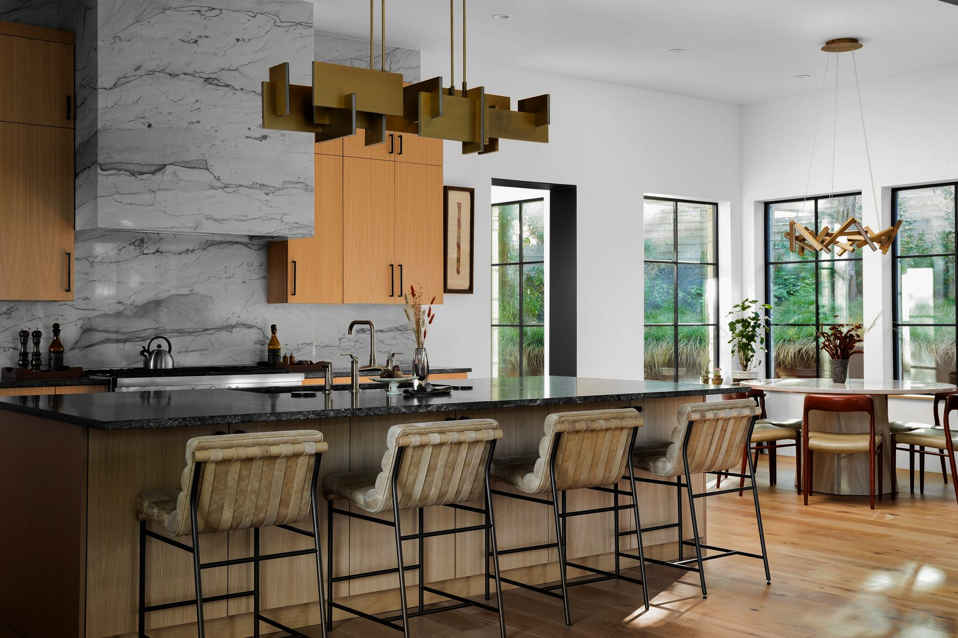 A living room with two chairs , a table , a lamp and a ladder.