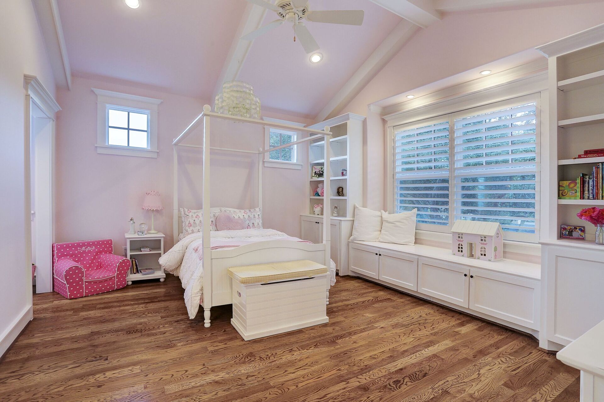 A bedroom with a canopy bed and a window seat.