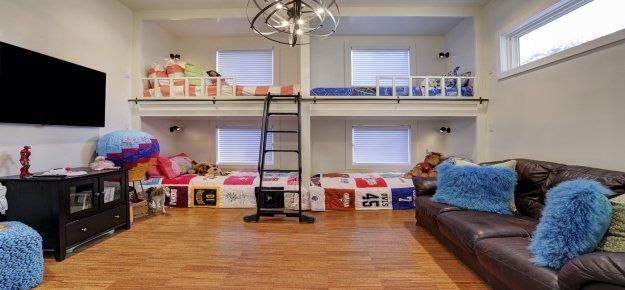 A living room with bunk beds , a couch , and a television.
