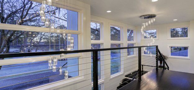 A staircase with a railing and lots of windows in a house.