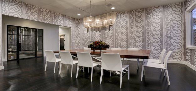 A dining room with a long table and chairs and a chandelier.