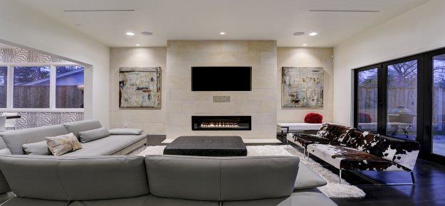 A living room with a couch , fireplace and television.