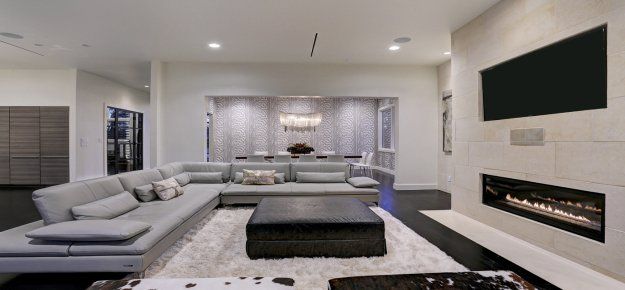A living room with a couch , fireplace and television.